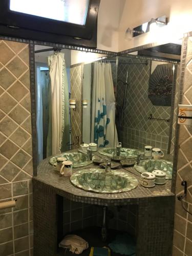 ラ・マッダレーナにあるvilla palmaの洗面台と大きな鏡のあるバスルーム