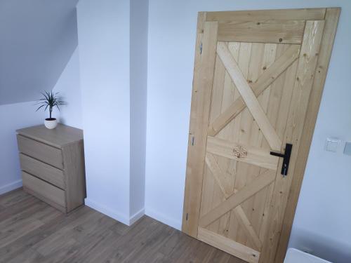 a wooden door in a room with a dresser at Przystanek Gorce in Nowy Targ