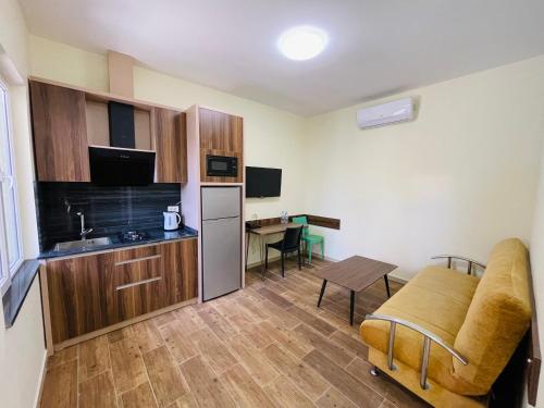 a small kitchen with a couch and a table at Calligraphy Hotel and Cottages in Mtsvane Kontskhi