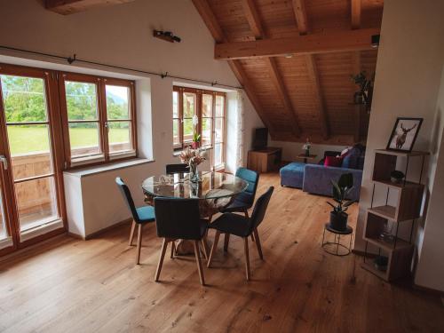 uma sala de estar com uma mesa de vidro e cadeiras em Ferienhof Kohler em Bichl