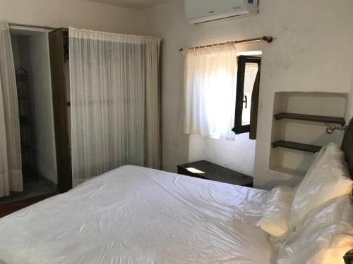 ラ・マッダレーナにあるvilla palmaの白いベッドと窓のある寝室