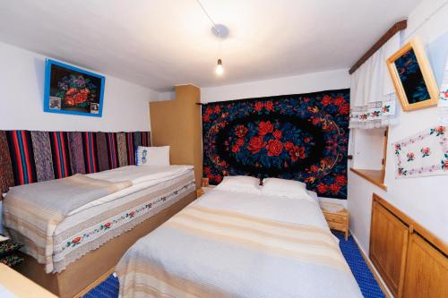 1 dormitorio con 2 camas y tapiz en la pared en Gagauz Sofrasi, en Congaz