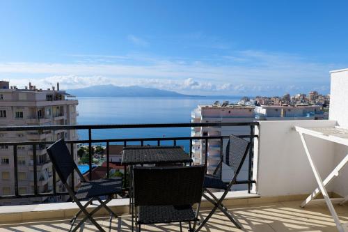 einen Balkon mit Stühlen und Blick auf das Wasser in der Unterkunft Albania Dream Holidays Accommodation in Sarandë