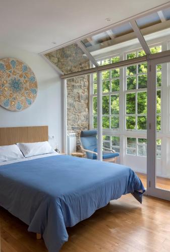 a bedroom with a blue bed and a blue chair at Apartamentos Bestarruza in Mugardos