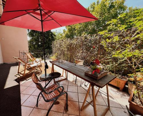 a wooden table with a red umbrella on a patio at B&B La Bugia di Villa Tanzi in Parma