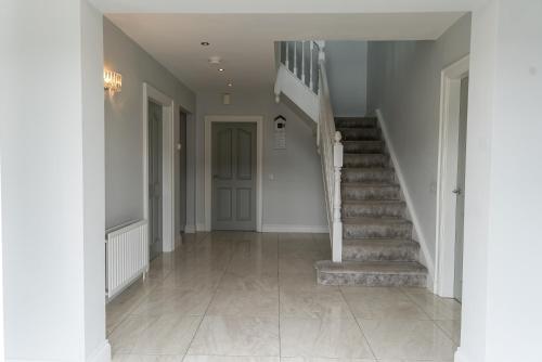 a hallway of a home with a staircase and a stair case at Maple Grove, Fahan in Fahan