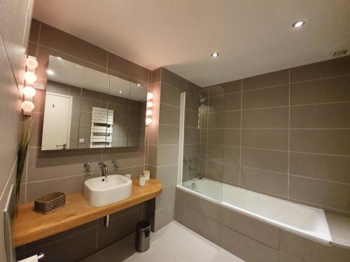 a bathroom with a sink and a bath tub at Appartement Marquise de 110m2 avec vue et sauna à 10 min des pistes in Sainte-Foy-Tarentaise