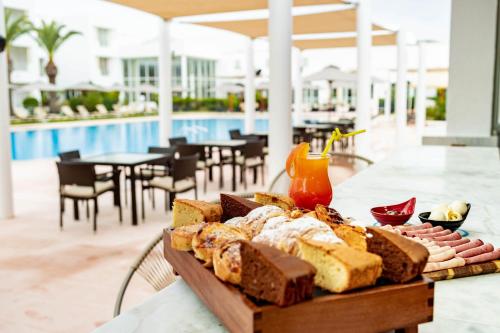 a tray of bread on a table next to a pool at TMK Flora Park by Turismark - Adults Only in Hammamet
