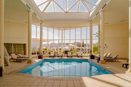 a pool in a hotel with a glass ceiling at TMK Flora Park by Turismark - Adults Only in Hammamet
