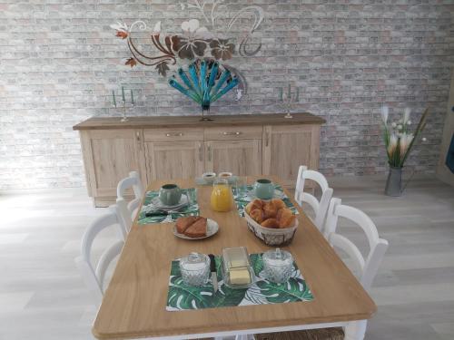 a dining room table with a plate of food on it at le bonheur des plumes in Montmartin-en-Graignes