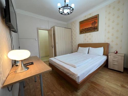 a small bedroom with a bed and a table at Khongor Guest house & Tours in Ulaanbaatar
