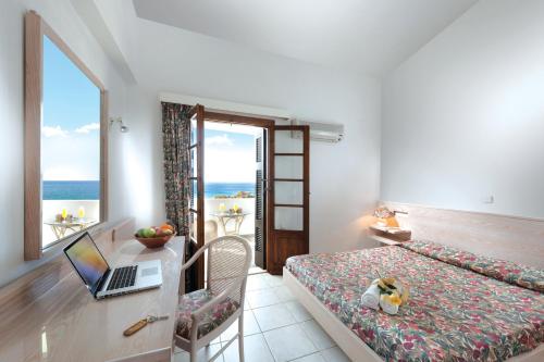 sypialnia z łóżkiem i laptopem na biurku w obiekcie Niriides Apartments w mieście Kipri