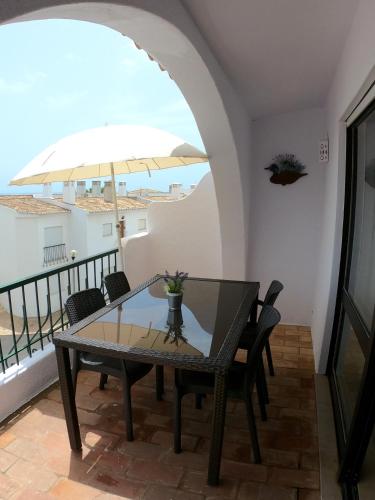 a dining room with a table and an umbrella at Casa Vista Mar in Luz