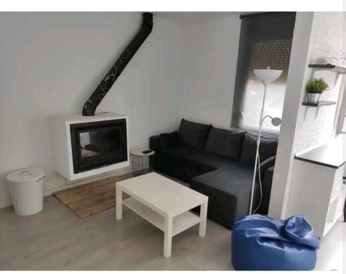 salon z czarną kanapą i stołem w obiekcie Apartamento en el pirineo catalan w mieście Sant Jordi de Cercs