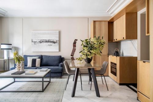 a living room with a table and a blue couch at Ayala 63 - THE ARC COLLECTION in Madrid
