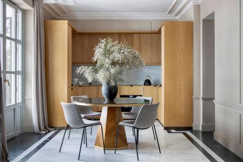 a dining room with a table with chairs and a vase with flowers at Ayala 63 - THE ARC COLLECTION in Madrid