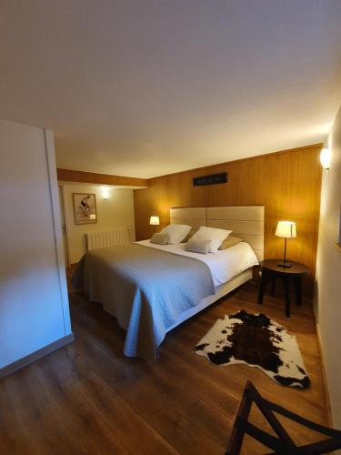 une chambre avec un grand lit blanc et un parquet dans l'établissement Appartement Gentiane de 85m2 avec sauna à 10 min des pistes, à Sainte-Foy-Tarentaise