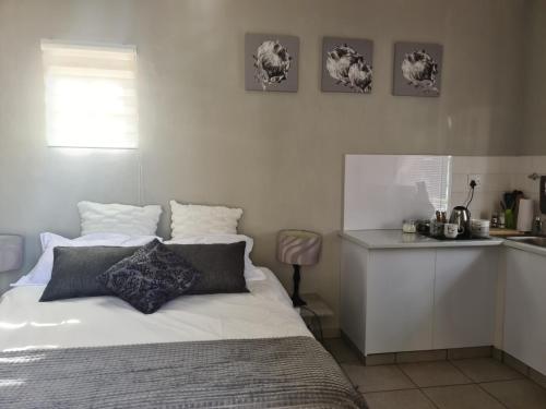 Un dormitorio con una cama blanca y una cocina. en Sleep At Solomon 8A, en Kimberley