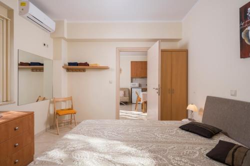 1 Schlafzimmer mit einem großen Bett und einer Küche in der Unterkunft Luxury Coastal Retreat, Mountain View Balcony with Palm Trees & Parking in Chania