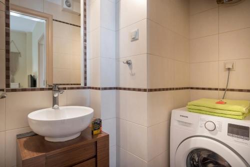 ハニア・タウンにあるLuxury Coastal Retreat, Mountain View Balcony with Palm Trees & Parkingの洗面台と洗濯機を備えたバスルーム