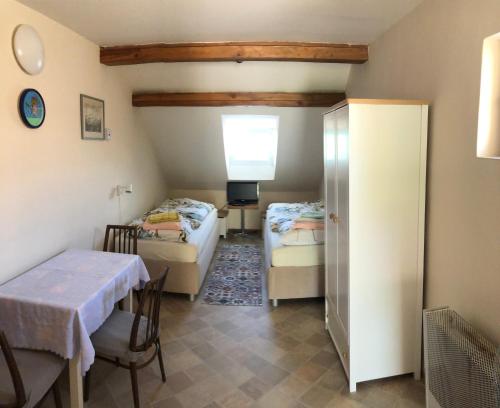 ミクロフにあるUbytování u Jeřábkůのベッド2台とテーブルが備わる小さな客室です。