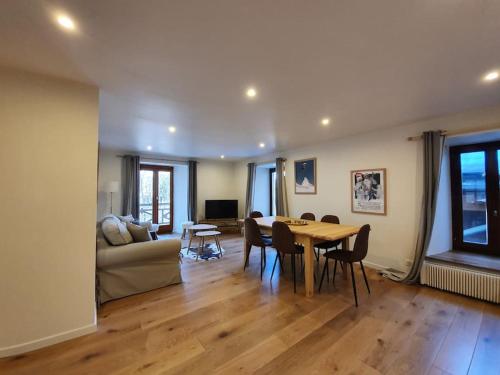 a living room with a table and a couch at Appartement Marquise de 110m2 avec vue et sauna à 10 min des pistes in Sainte-Foy-Tarentaise