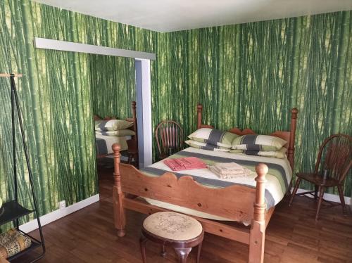 - une chambre avec un lit et du papier peint vert dans l'établissement Colourful well equipped 2-Bed House in Le Vigeant, à Le Vigeant