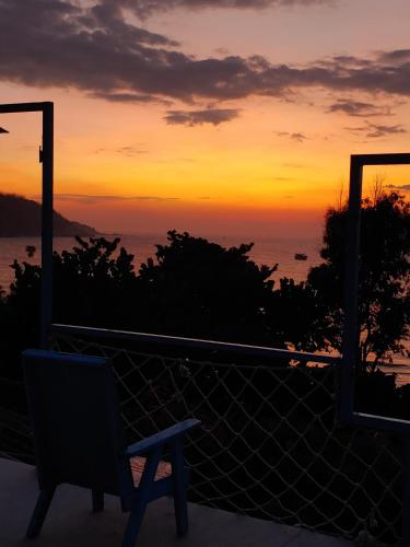 a chair sitting on a balcony watching the sunset at nhà Ba cơm Má in Phương Phi