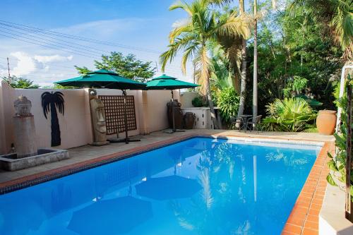 KitweにあるShamba Lodgeの庭にあるパラソル付きの青いプール
