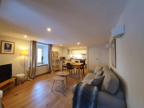 a living room with a couch and a table at Appartement Gentiane de 85m2 avec sauna à 10 min des pistes in Sainte-Foy-Tarentaise