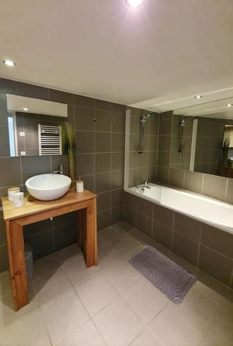 une salle de bain avec un lavabo et une baignoire dans l'établissement Appartement Gentiane de 85m2 avec sauna à 10 min des pistes, à Sainte-Foy-Tarentaise