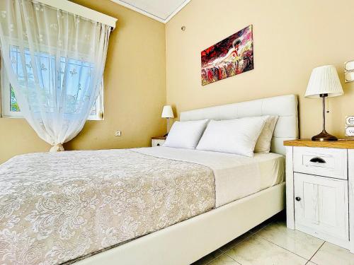 een slaapkamer met een wit bed en een raam bij Christina_Apt in Chania