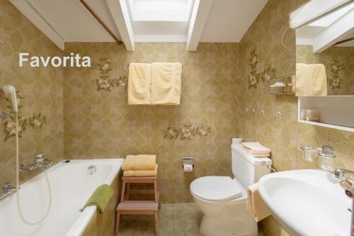 ツェルマットにあるスイスフレア アパートメントのバスルーム(バスタブ、トイレ、シンク付)