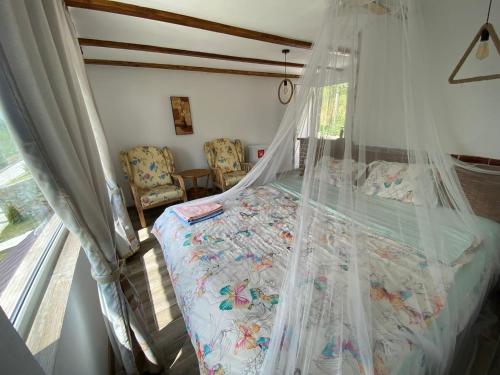 a bedroom with a bed with a mosquito net at Casutele verzi din Ocnele Mari in Ocnele Mari