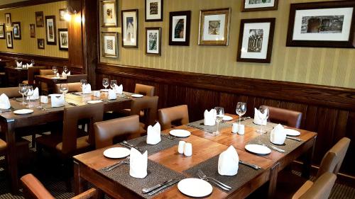 comedor con mesas y sillas de madera en Premier Hotel Regent, en East London