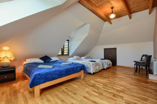 two beds in a large room with wooden floors at Bereszczańskie Sioło in Berezka