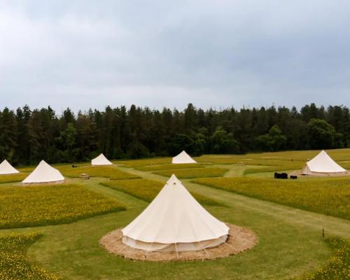 a group of white tents on a golf course at Forest Edge Glamping in Gittisham