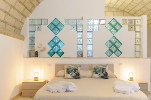 a bedroom with a bed with pillows and windows at Villa Franca in Bari