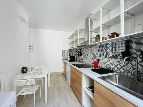 una cocina con fregadero y mesa. en DnN - Modern 1 BR, center Thiers - free Wifi and parking - near Lyon, Vichy, Clermont en Thiers