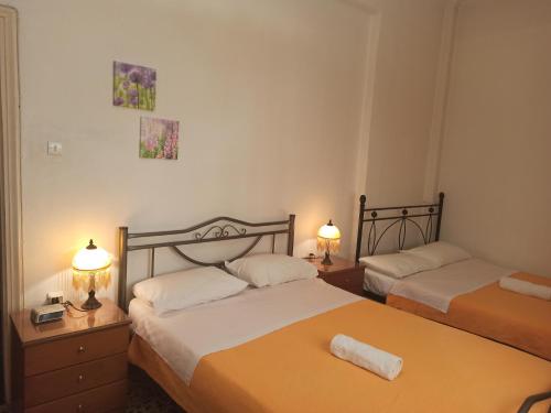 2 camas en una habitación pequeña con 2 lámparas en Entire House with garage, yard at Amfiali close to Piraeus Port, en Pireo