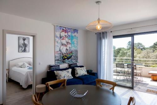 un salon avec un lit et une table de salle à manger dans l'établissement Domaine d'Arca Porto Vecchio - 