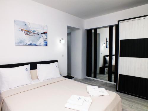 a bedroom with a bed with two towels on it at Ada Luxury Apartments 43 in Mamaia