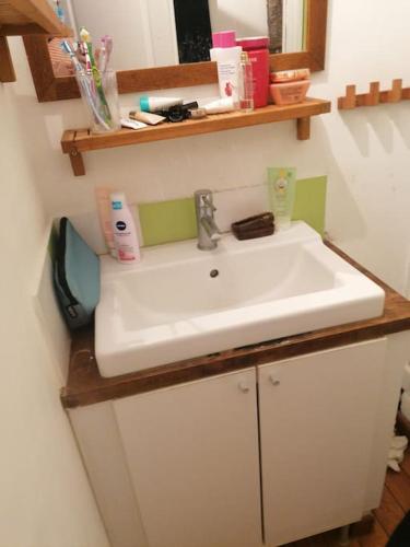 une salle de bain avec un lavabo blanc et un miroir dans l'établissement VERDON GRAN VALA 2 les pieds dans l'eau, à Martigues