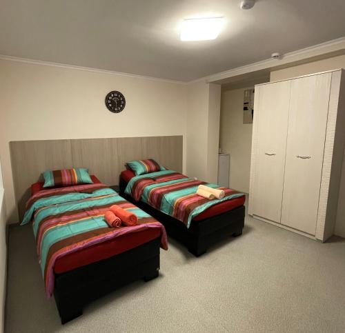 a bedroom with two beds and a cabinet at Butas Senamiestyje in Rokiškis