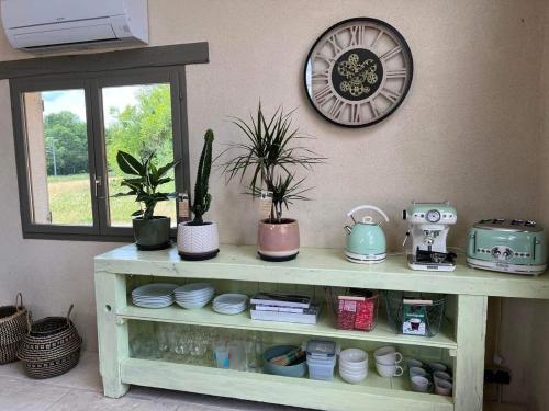 a shelf with plants and a clock on a wall at Une pause s'impose ;) in Méry-sur-Cher