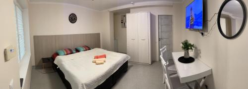 1 dormitorio con cama, mesa y espejo en Butas Senamiestyje, en Rokiškis