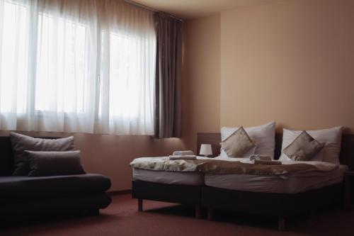 a bedroom with a bed with pillows and a window at Centrooms Eger in Eger