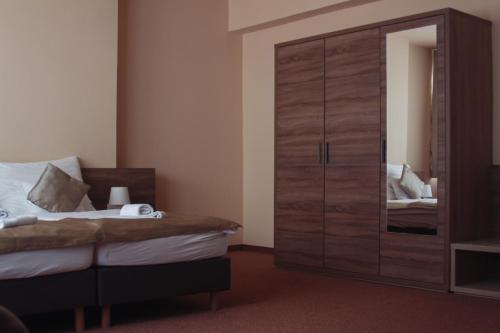 a bedroom with a large wooden wardrobe and a bed at Centrooms Eger in Eger