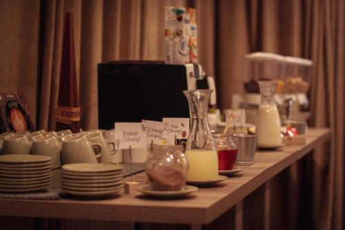 a long table with plates and cups and milk at Centrooms Eger in Eger