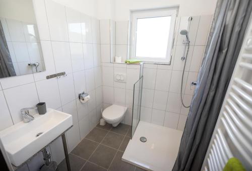 Baño blanco con aseo y lavamanos en Apartment Karlo, en Radatovići